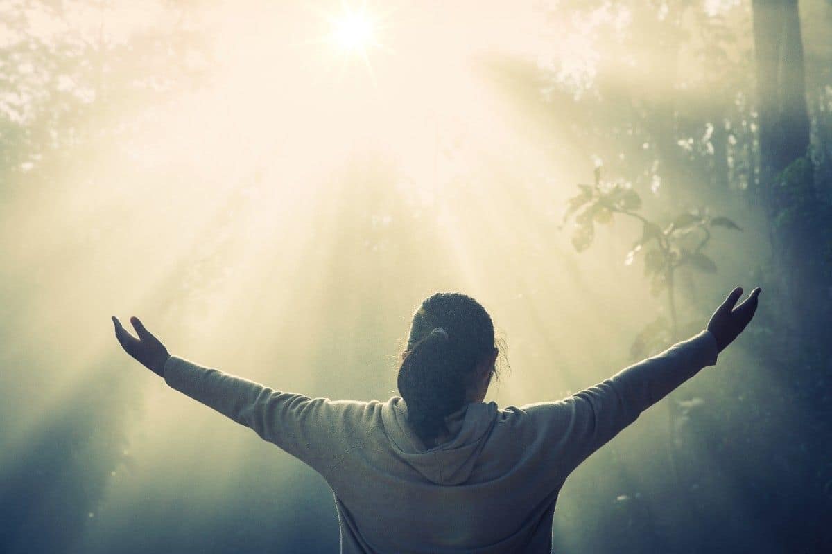 A person sitting in quiet reflection, hands open, finding peace and hope
